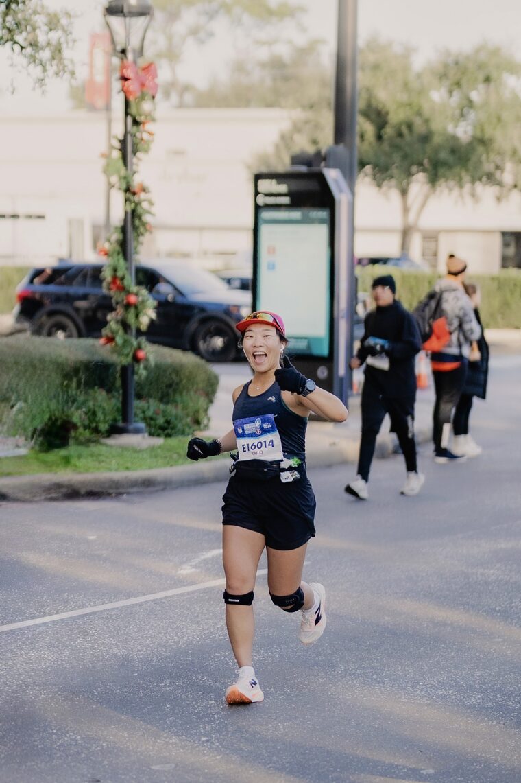 Chloe mid-race, giving a thumbs up during a marathon